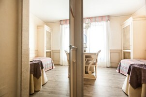 A room with two beds, a table, and a chair.