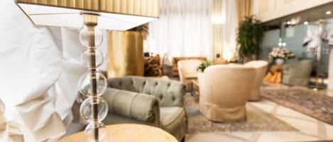 Een goed verlichte woonkamer met een moderne lamp, een ronde salontafel en een comfortabele fauteuil.