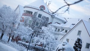 Un edificio cubierto de nieve con un techo curvo característico y numerosas ventanas.