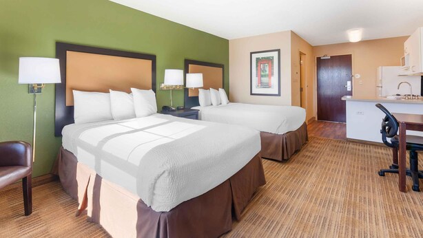 A hotel room with two beds, a desk, a chair, a lamp, and a framed picture on the wall. - Extended Stay America Select Suites - Appleton - Fox Cities (Appleton)