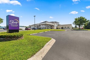 Een Sleep Inn & Suites by Choice Hotels met een parkeerplaats en een gebouwde ingang.