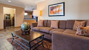 Un moderno vestíbulo de hotel con un sofá marrón, un globo terráqueo sobre un soporte de madera y un cuadro abstracto enmarcado en la pared.