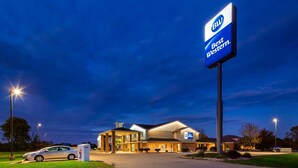 Un hotel Best Western con un letrero grande, un estacionamiento y un paquete de FedEx en el suelo.