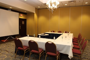 A conference room with a long table, chairs, and a projector screen. - Holiday Inn Budd Lake - Rockaway Area by IHG (Budd Lake)