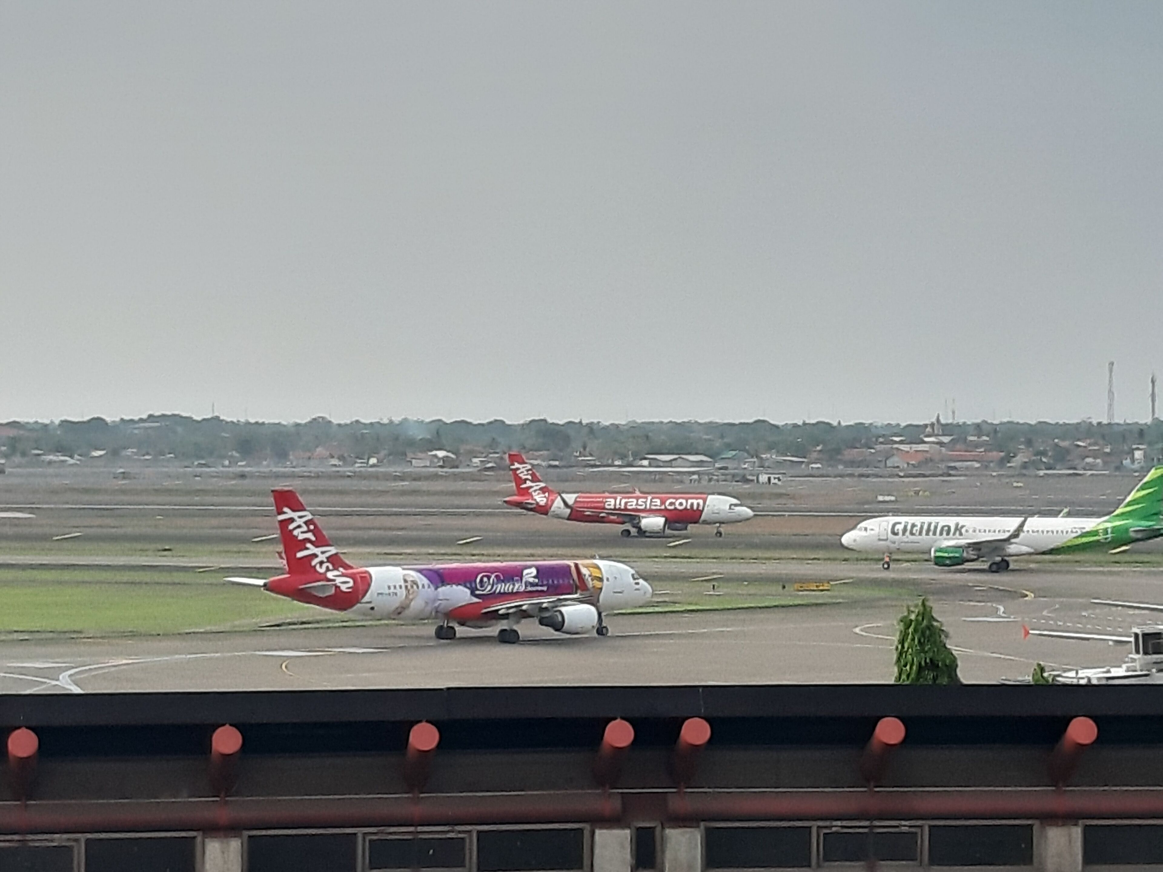 An airport runway with multiple airplanes parked.