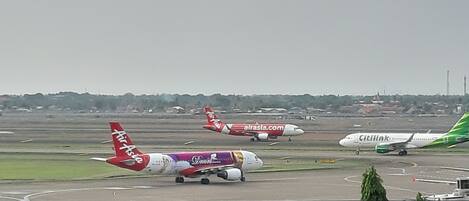 An airport runway with multiple airplanes parked.