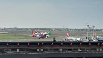 Pista de aeroporto com vários aviões estacionados.