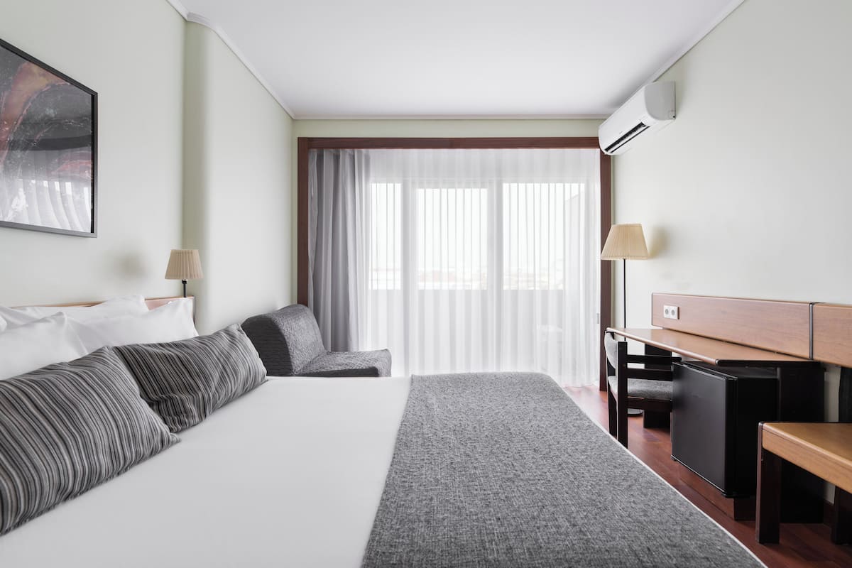 Familiekamer, uitzicht op stad | Een minibar, een kluis op de kamer, een bureau, geluiddichte muren