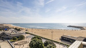 Una playa con muelle, edificios y cielo despejado.