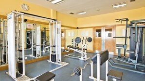 A gym with various exercise equipment, mirrors, and a clock on the wall. - Lam Hotel Caramulo  (Tondela)