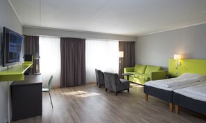 A hotel room with a bed, a desk with a computer, a chair, a sofa, and a TV. - Thon Hotel Hallingdal (Al)
