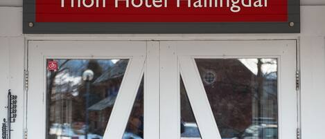 Entrada de un hotel con un cartel que dice 'Thon Hotel Hallingdal'.