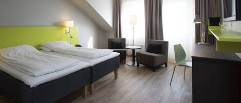 Une chambre d’hôtel avec deux lits, un bureau, une chaise, une lampe et un téléviseur.
