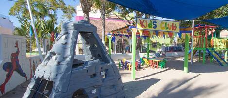 A children's play area with a climbing structure and a sign that reads "Kids Club".