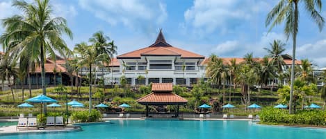 Una piscina al aire libre, sombrillas, sillones reclinables de piscina