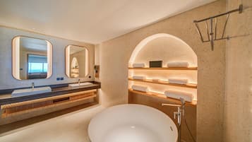 A modern bathroom with a large freestanding sink, dual mirrors, and built-in shelves with towels.