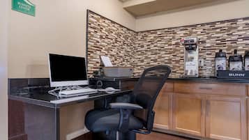 Een businesscenter met een computer, een koffieapparaat en een Bunn koffiezetapparaat.