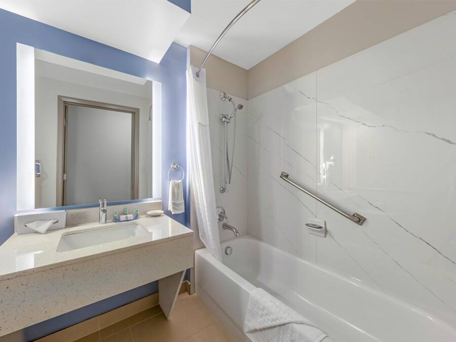 Un baño con bañera, ducha, lavabo y espejo.
