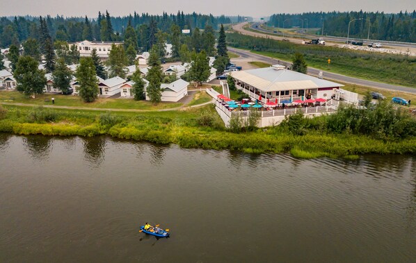Un edificio junto al lago con un muelle y un kayak en el agua.