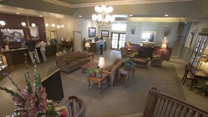 A hotel lobby with a reception desk, seating area, and staircase. - Rivers Edge Resort (Fairbanks)