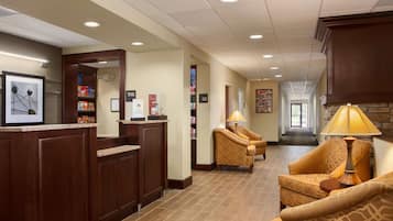 A reception area with a counter, seating, and a hallway leading to a door.