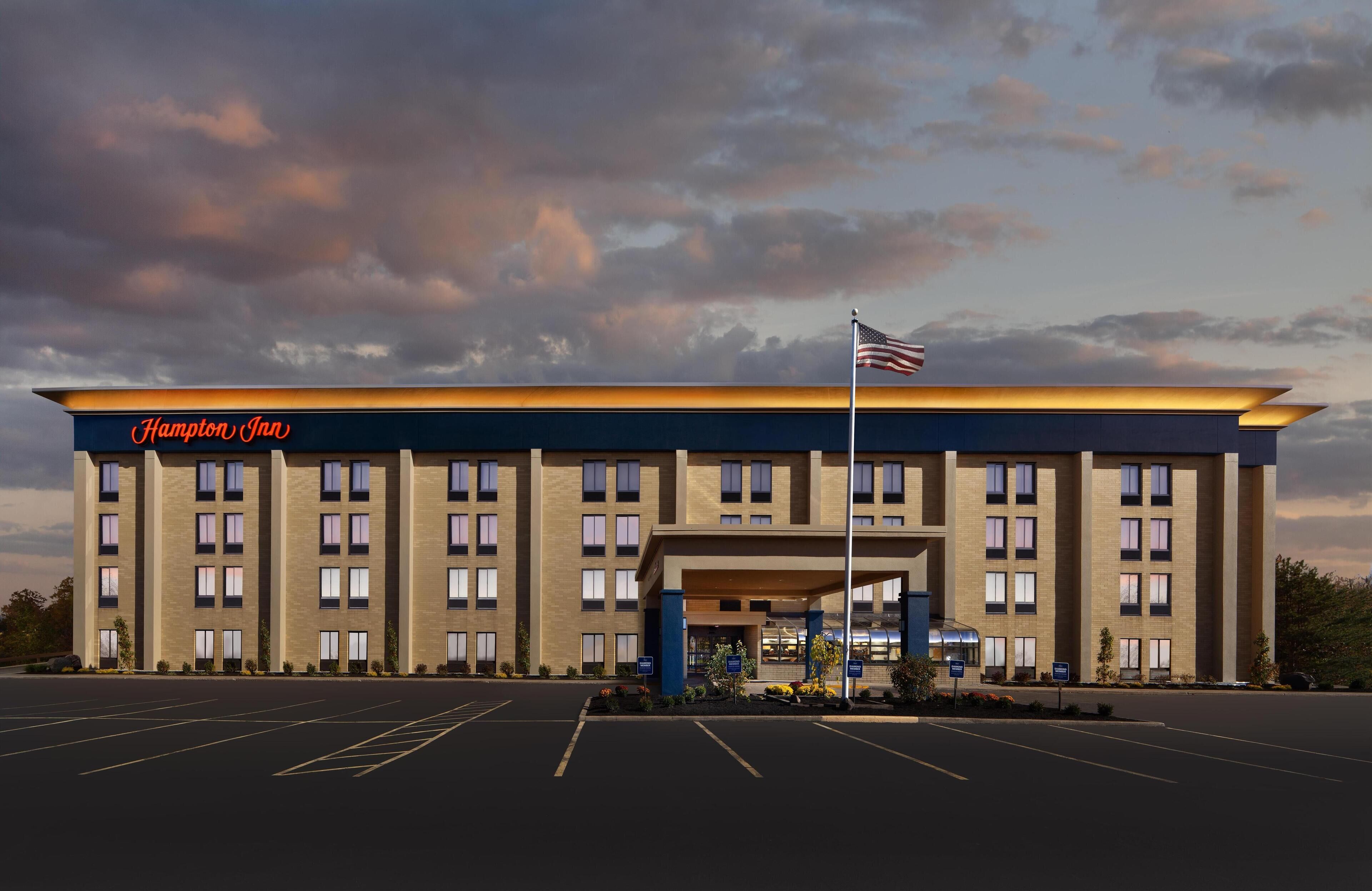 Un hotel Hampton Inn con estacionamiento y una entrada cubierta.