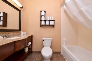 A bathroom with a sink, toilet, and bathtub. There is a shelf with toiletries above the toilet. - Hampton Inn Elkhart IN (Elkhart)