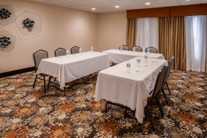 A conference room with two tables, chairs, water bottles, and a patterned carpet. - Hampton Inn Elkhart IN (Elkhart)