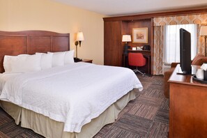 A hotel room with a large bed, a desk with a chair, a television, and a window with curtains. - Hampton Inn Elkhart IN (Elkhart)