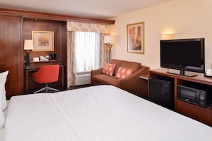 A hotel room with a bed, a desk with a chair, a television, a microwave, and a heater. - Hampton Inn Elkhart IN (Elkhart)