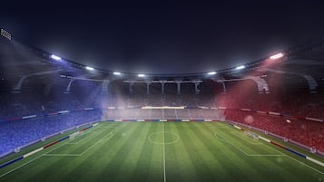 Un grand stade intérieur doté d’un terrain vert, de zones réservées aux spectateurs et d’une structure de toit.