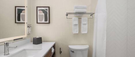 Un baño moderno con un lavamanos blanco, un inodoro y una cortina de ducha.