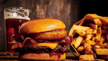 A burger with bacon, cheese, and a side of fries.