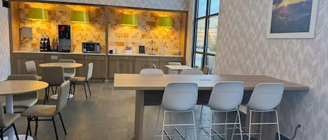 Una cocina moderna con dos zonas de bar, taburetes y una mesa de comedor con sillas.