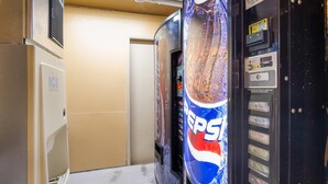 A vending machine with a Pepsi logo, a coin slot, and a selection panel.