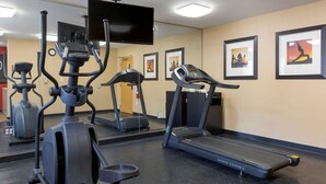 A gym with various exercise equipment including treadmills, stationary bikes, and elliptical machines.