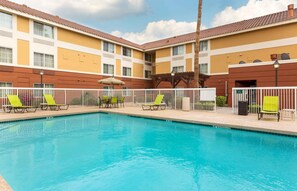 A swimming pool with lounge chairs and a building with a tiled roof. - Extended Stay America Suites Phoenix Scottsdale (Scottsdale)