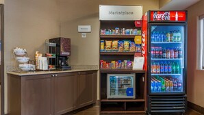 A kitchenette area with a refrigerator stocked with beverages, a microwave, and a coffee machine.