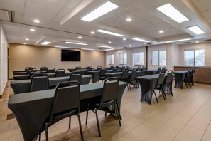 A conference room with multiple tables and chairs, a flat-screen TV, and large windows. - Comfort Suites Highlands Ranch Denver Tech Center Area (Littleton)
