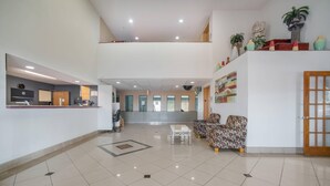 A spacious lobby with a reception desk, seating area, and a staircase leading to an upper level. - Quality Inn O'Fallon - St. Louis - Shiloh (O'Fallon)