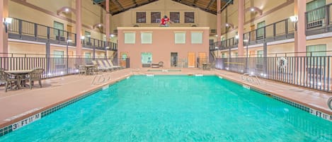 Ein Innenpool mit mehreren Balkonebenen, Liegestühlen und einem Rettungsschwimmturm.