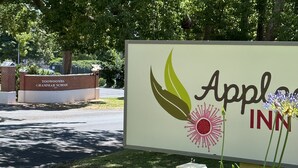 A sign for Appl INN with a logo featuring leaves and a flower.