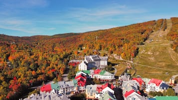 Une ville aux bâtiments aux couleurs vives, située au pied d’une colline boisée.
