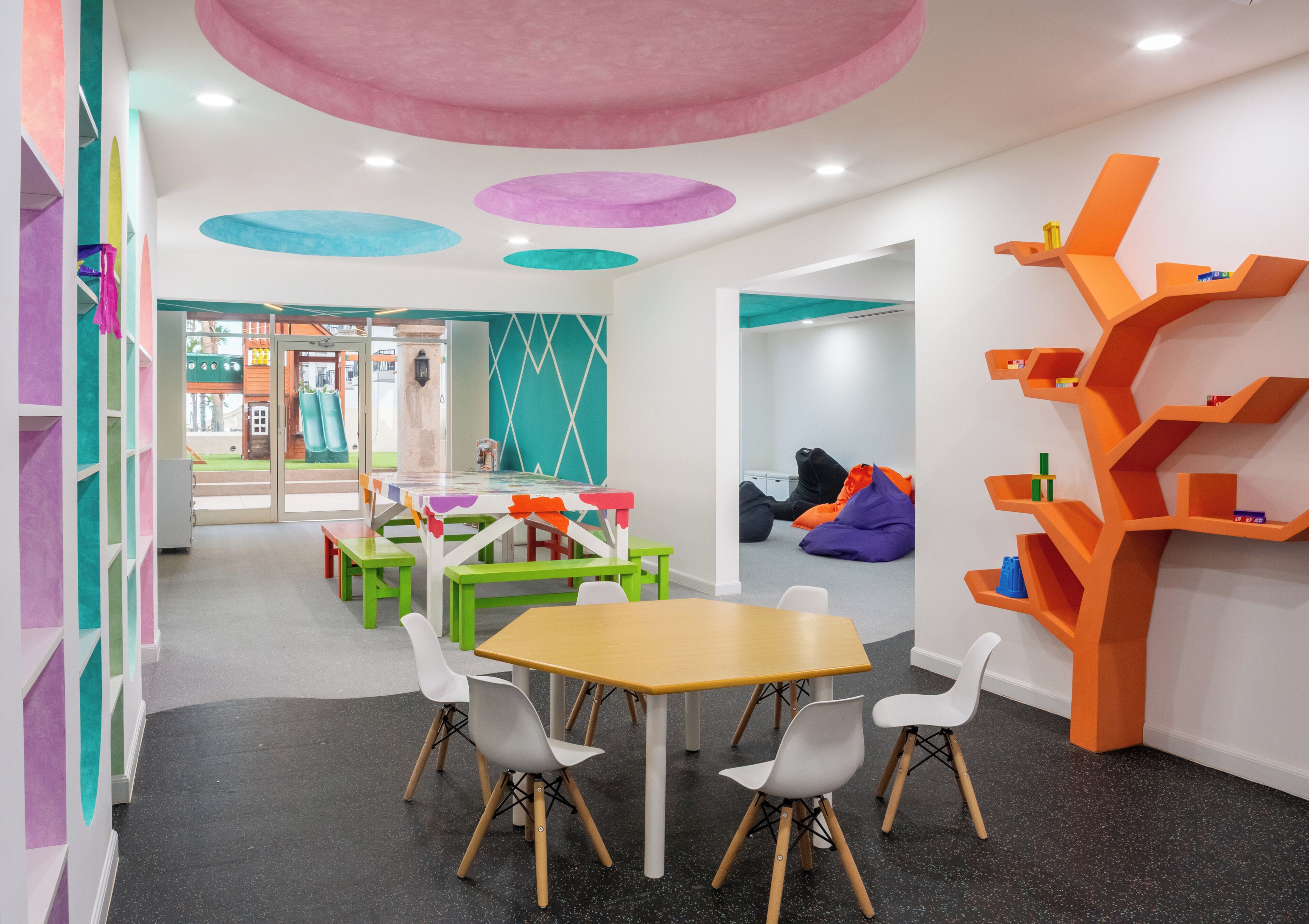 A children's play area with colorful furniture, a table, and bean bags.