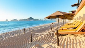 On the beach, white sand, sun loungers, beach umbrellas