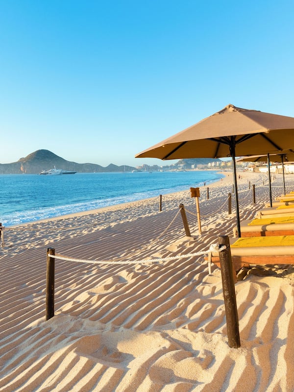 On the beach, white sand, sun loungers, beach umbrellas