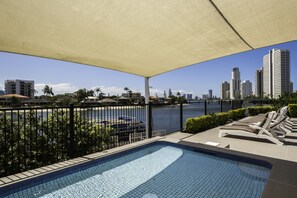 Una piscina al aire libre, camas de piscina gratis, sombrillas