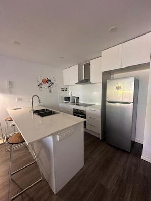 Fridge, microwave, stovetop, cookware/dishes/utensils - At Surfers Tradewinds (Gold Coast)