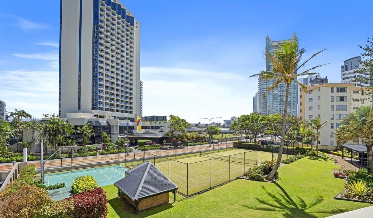 Un hôtel doté d’un court de tennis, d’une piscine et offrant une vue sur les grands immeubles.