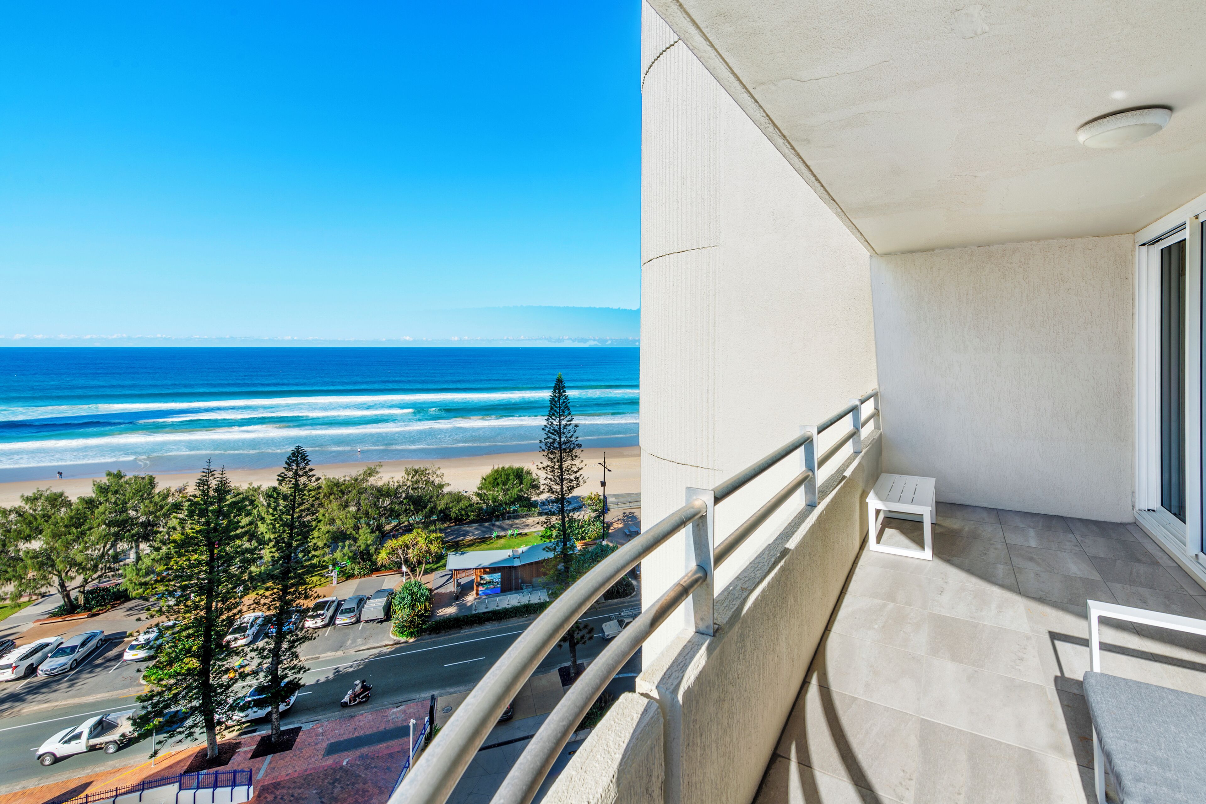 A balcony with a view of the beach and ocean.